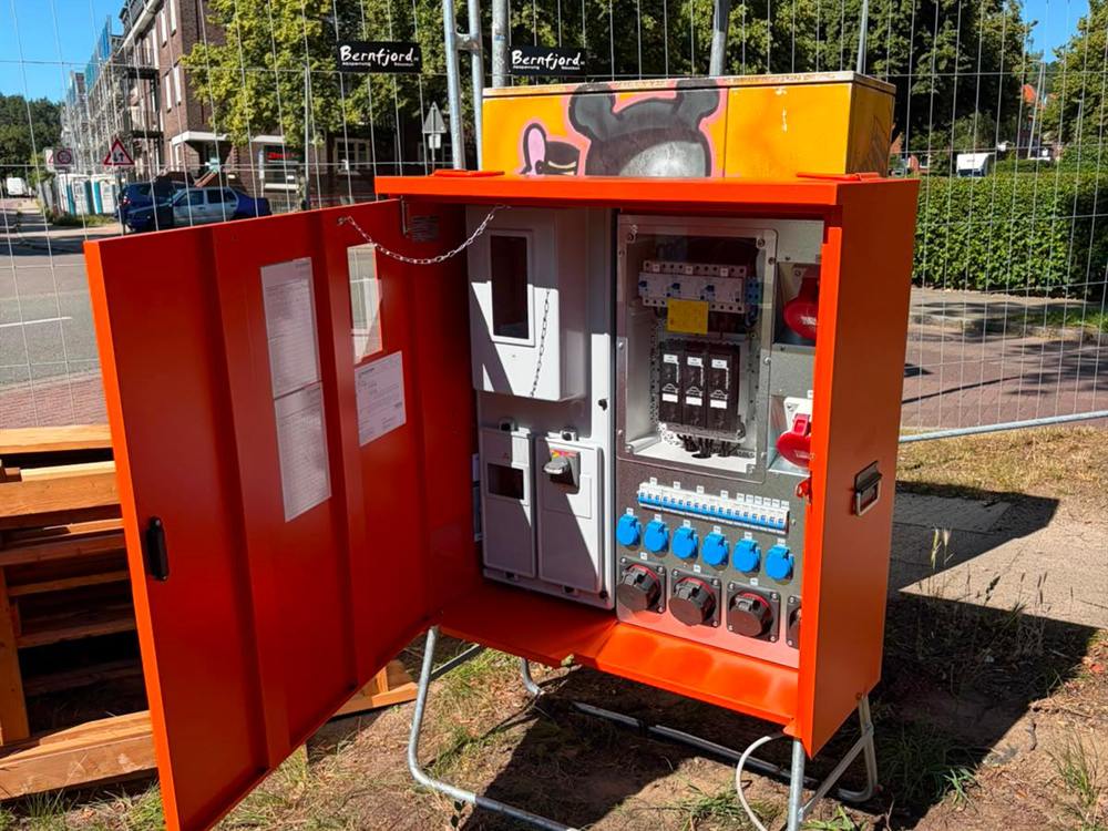 Aufgestellter Baustromverteiler mit geöffneter Tür auf einer Baustelle